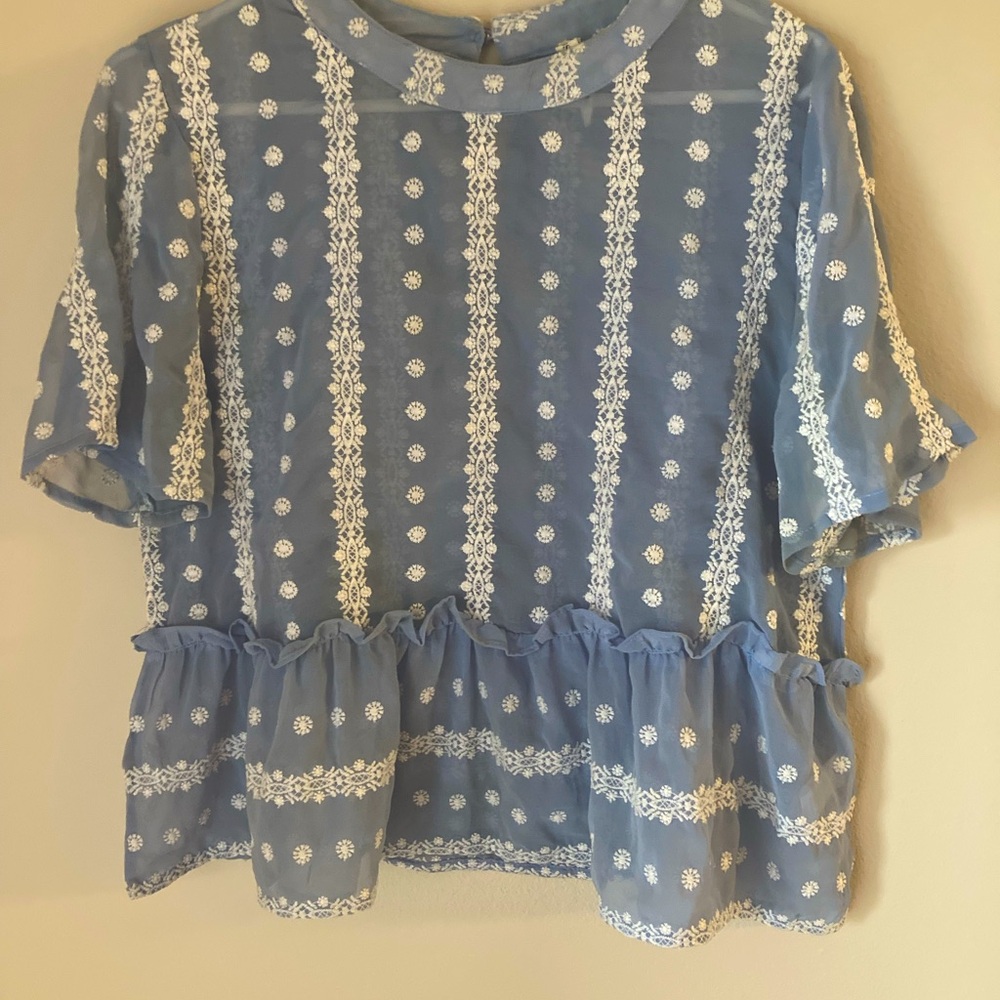 Blue sheer peplum top with white embroidery. Size Large.
